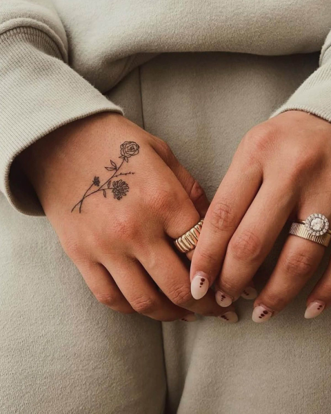 small flower rose tattoo on hand